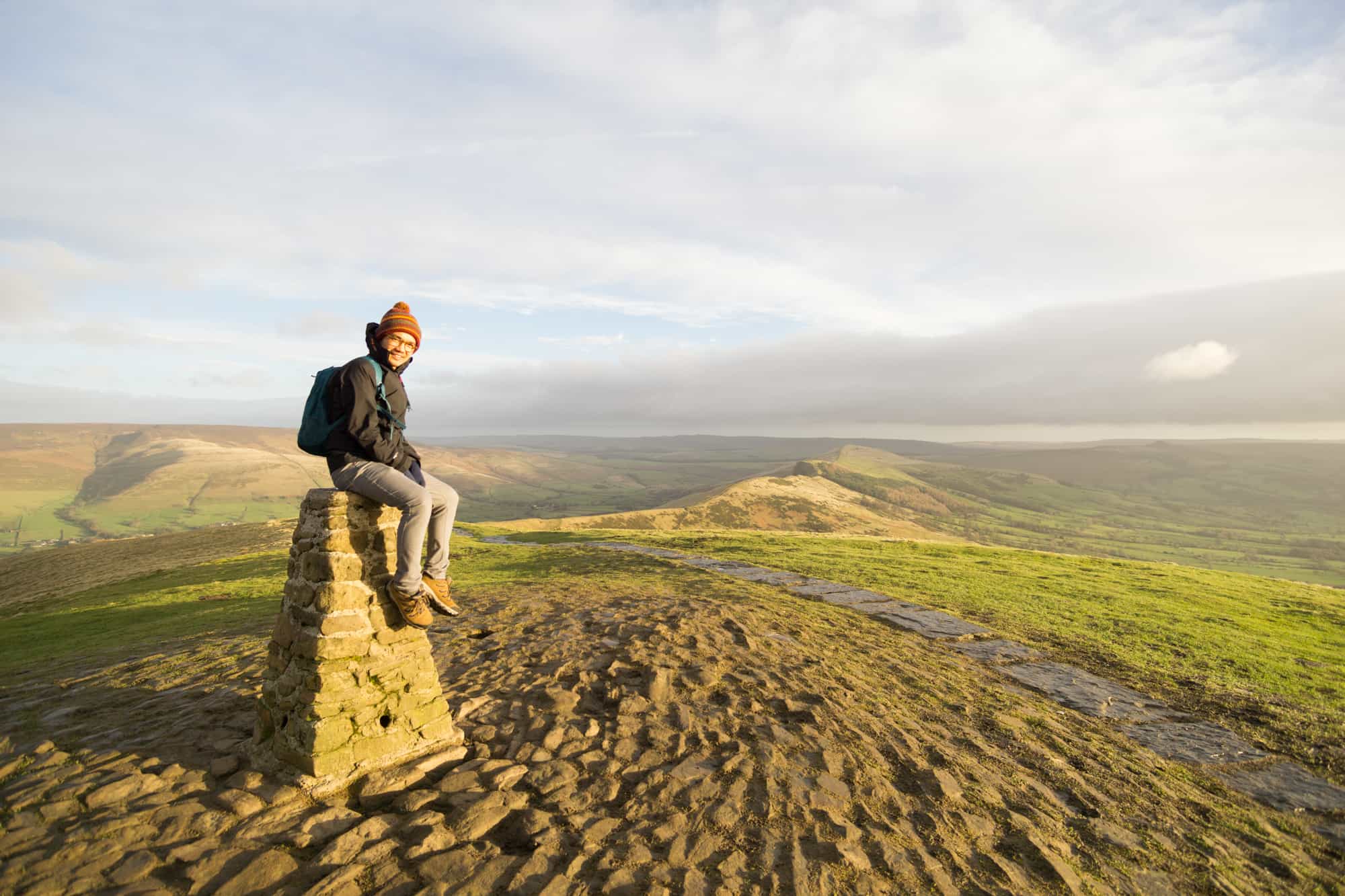 man sitting on trig point